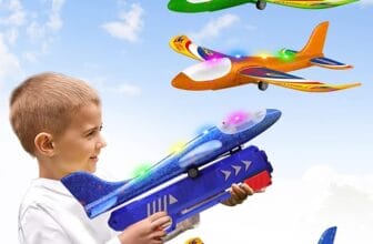 A young boy is smiling as he holds a blue foam airplane launcher toy, poised for play. The toy is vivid and colorful, featuring lights that add excitement to its appearance. Above him, three more foam airplanes with bright, multi-colored designs are captured in mid-flight against a clear sky with fluffy clouds, illustrating the potential for fun and engagement offered by these toys. The image conveys the joy and wonder of playing with flying toys outdoors.