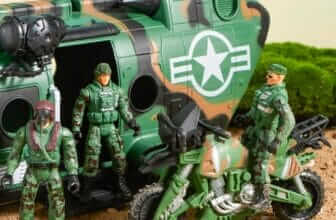 "Military helicopter toy with accompanying soldiers and motorcycle in a simulated battlefield environment."